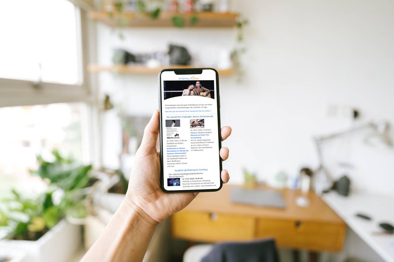 Person hält Smartphone mit OrtenauKultur Newsletter in der Hand